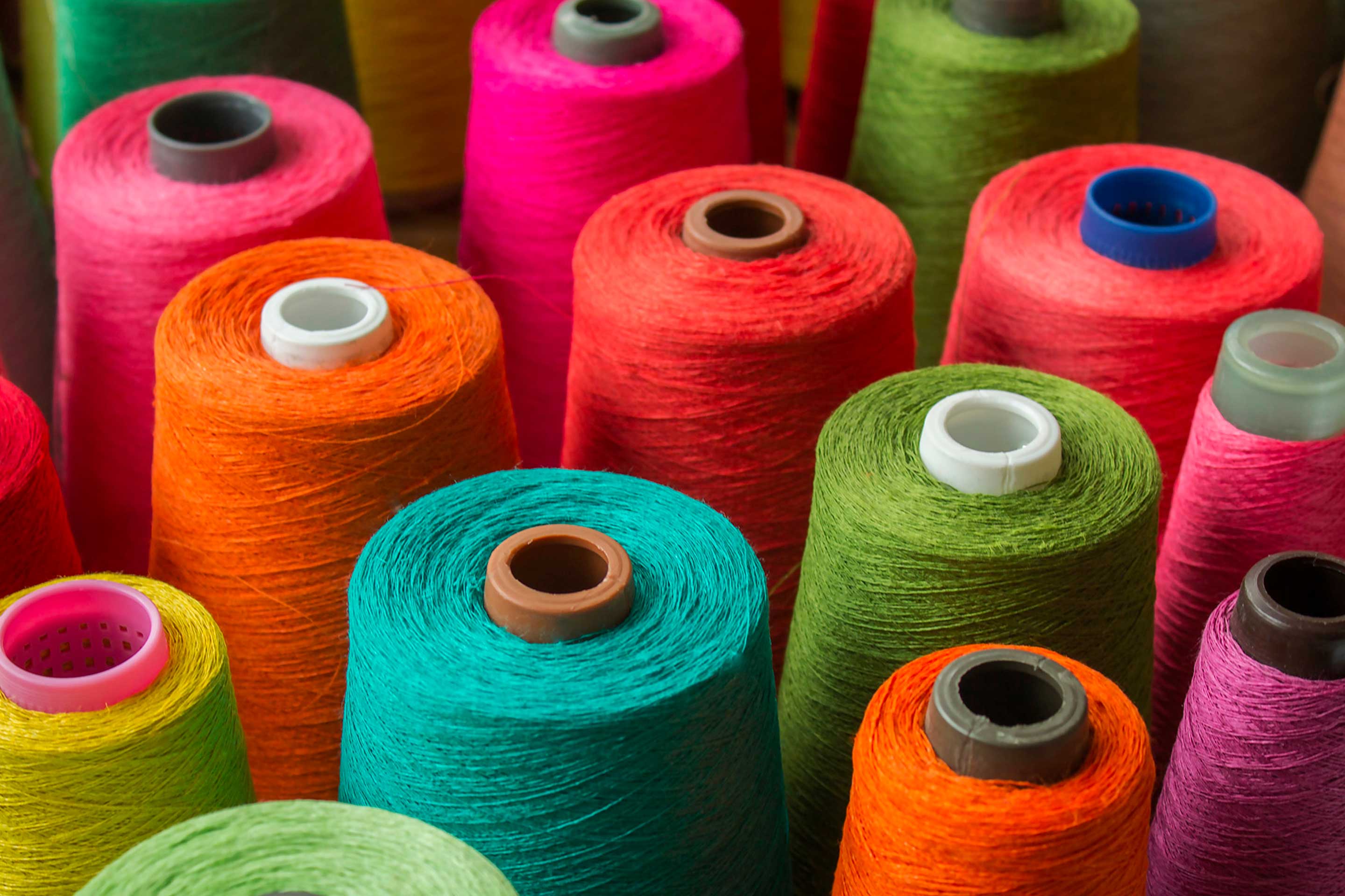 Different coloured cotton reels to make textiles